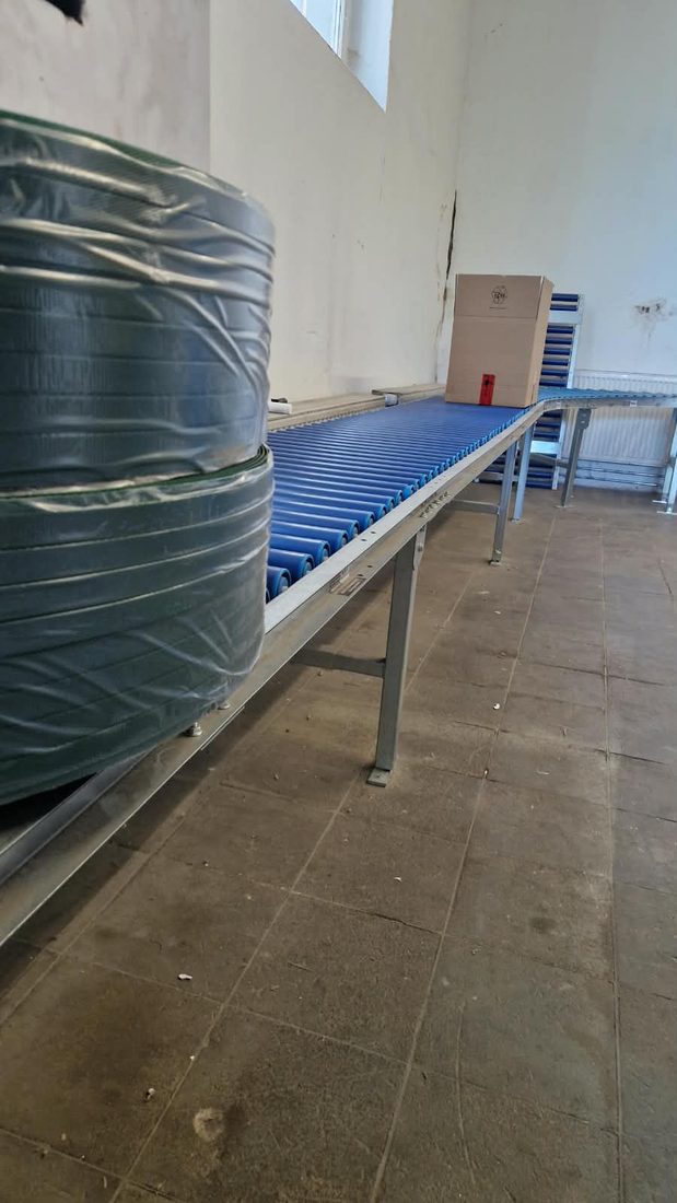 Rollenbahn im Versandbereich, dahinter Packtische